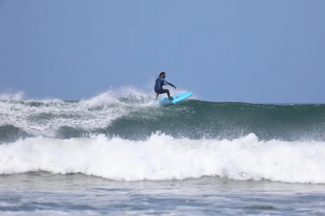 Un surfista sobre una ola en Nosara